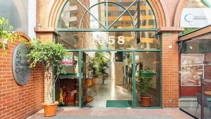 A building entrance with the number 1058, a glass door, and a potted plant outside. - Fontana Suites (Quito)