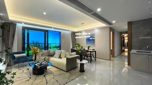 A modern living room with a sofa, coffee table, and dining area. There is a large window providing a view of the outdoors. - 3-bedroom, 2 bedroom, 1 livingroom, 1 kitchen with washer-dryer, WiFi, AC  (Shang Hai Shi)