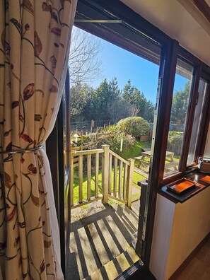 Vista desde una habitación con puerta corrediza de vidrio a una terraza exterior.
