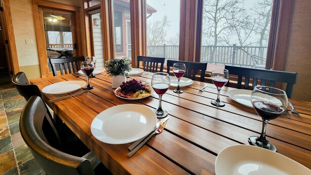 Een eettafel gedekt met borden, glazen en een decoratief middelpunt.