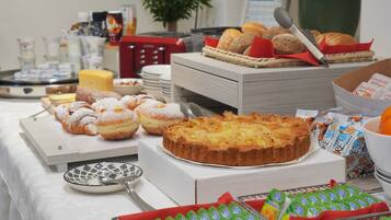 Een buffet met diverse gebakjes, taart en zuivelproducten.