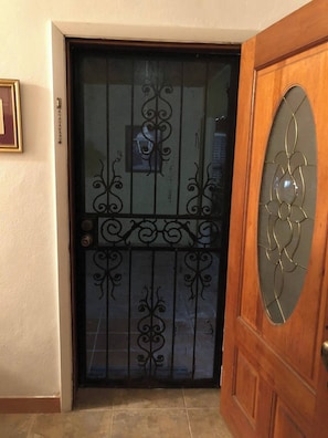 A beautifully designed entrance with a decorative glass panel and a framed picture.