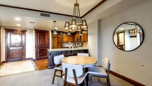 A dining area with a round table, chairs, and a chandelier.