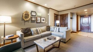 A living room with a sofa, coffee table, and wall decor.