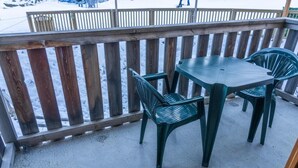 Une terrasse en bois avec une table et des chaises.