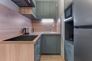 A modern kitchen with a built-in stove, a sink, and a microwave.