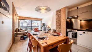 Eine moderne Küche mit Einbauofen und Essbereich mit Holztisch und Stühlen.