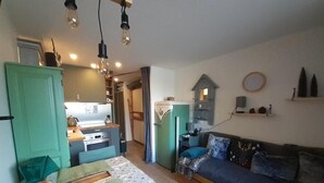 A compact living space with a kitchenette, a sofa, and a dining area.