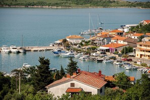 A marina with boats docked, surrounded by residential buildings with red-tiled roofs.
