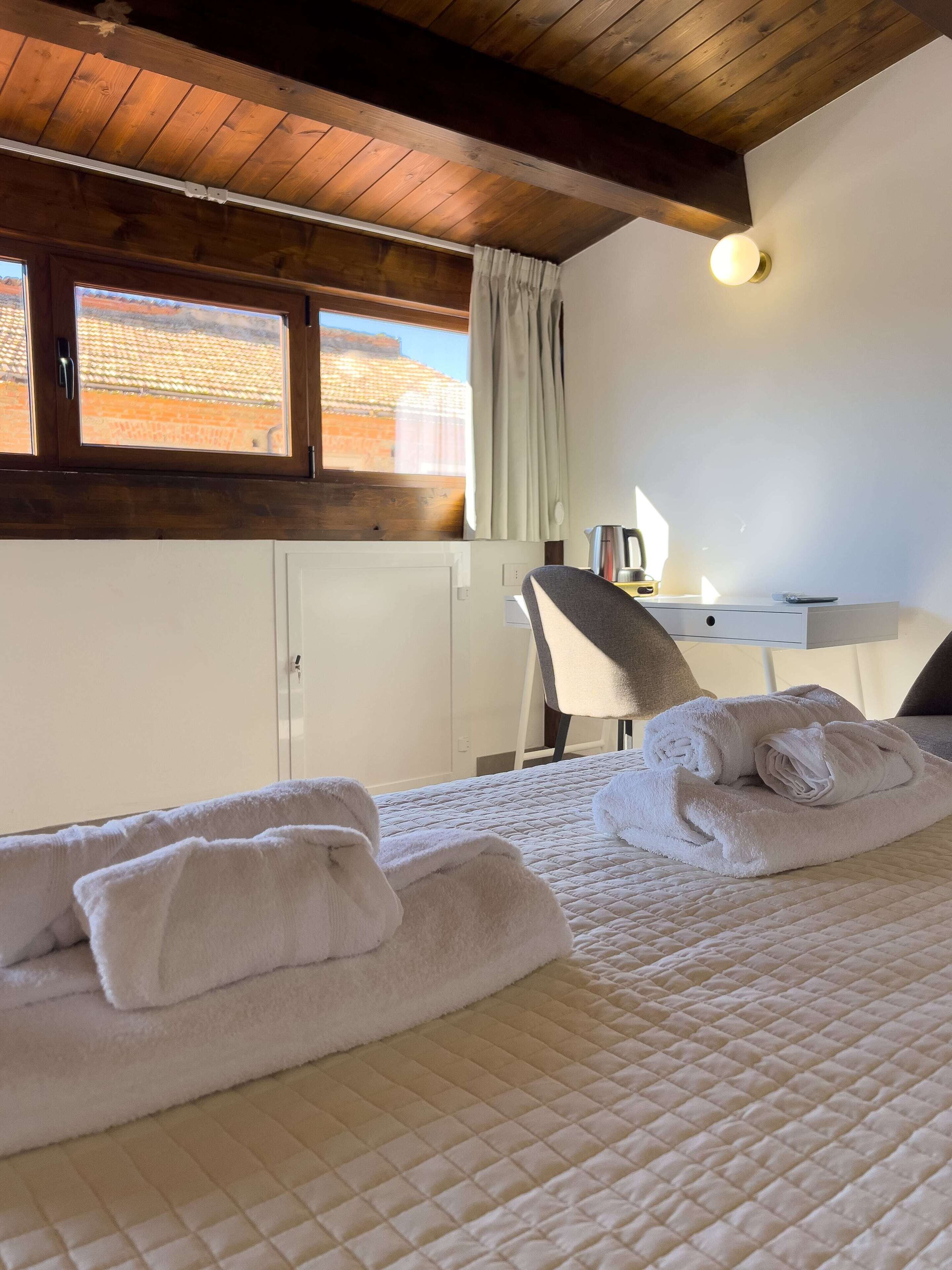 Een slaapkamer met een bed, een bureau en een stoel.