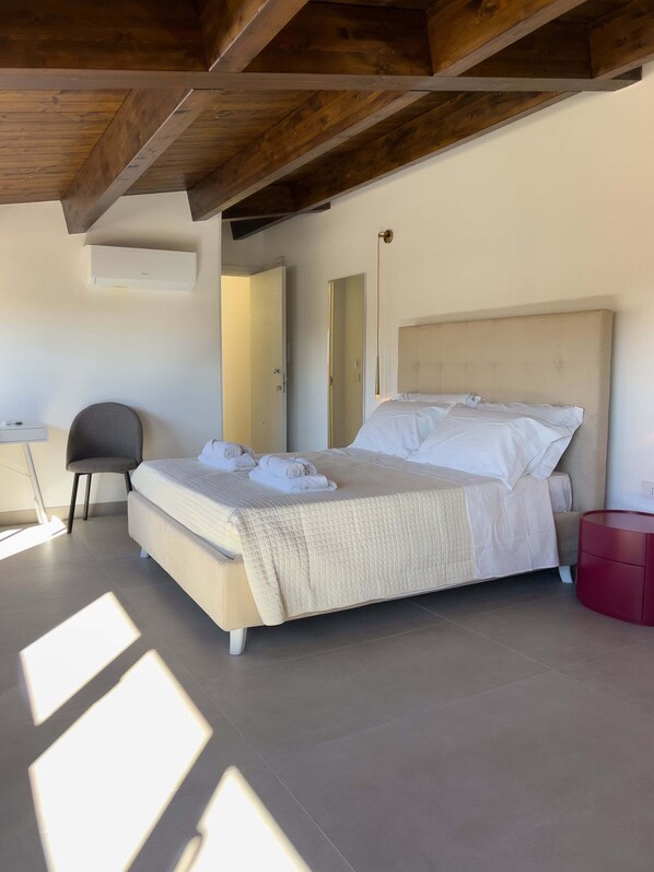 Un dormitorio con cama, una silla, mesita de noche y armario.