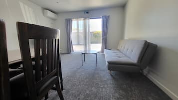 Suite familiar, vista al patio | Área de sala de estar | Televisión LED de 32 pulgadas con canales digitales