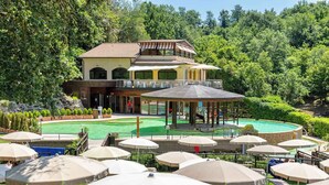 A two-story building with a pool and outdoor seating area. - Holiday apartment with air conditioning and pool (Sorano)