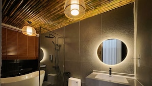 Une salle de bain moderne avec une baignoire sur pieds, des toilettes et un meuble-lavabo avec un miroir.