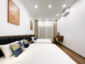 Habitación de hotel con dos camas, un tocador con espejo y un equipo de aire acondicionado en la pared.
