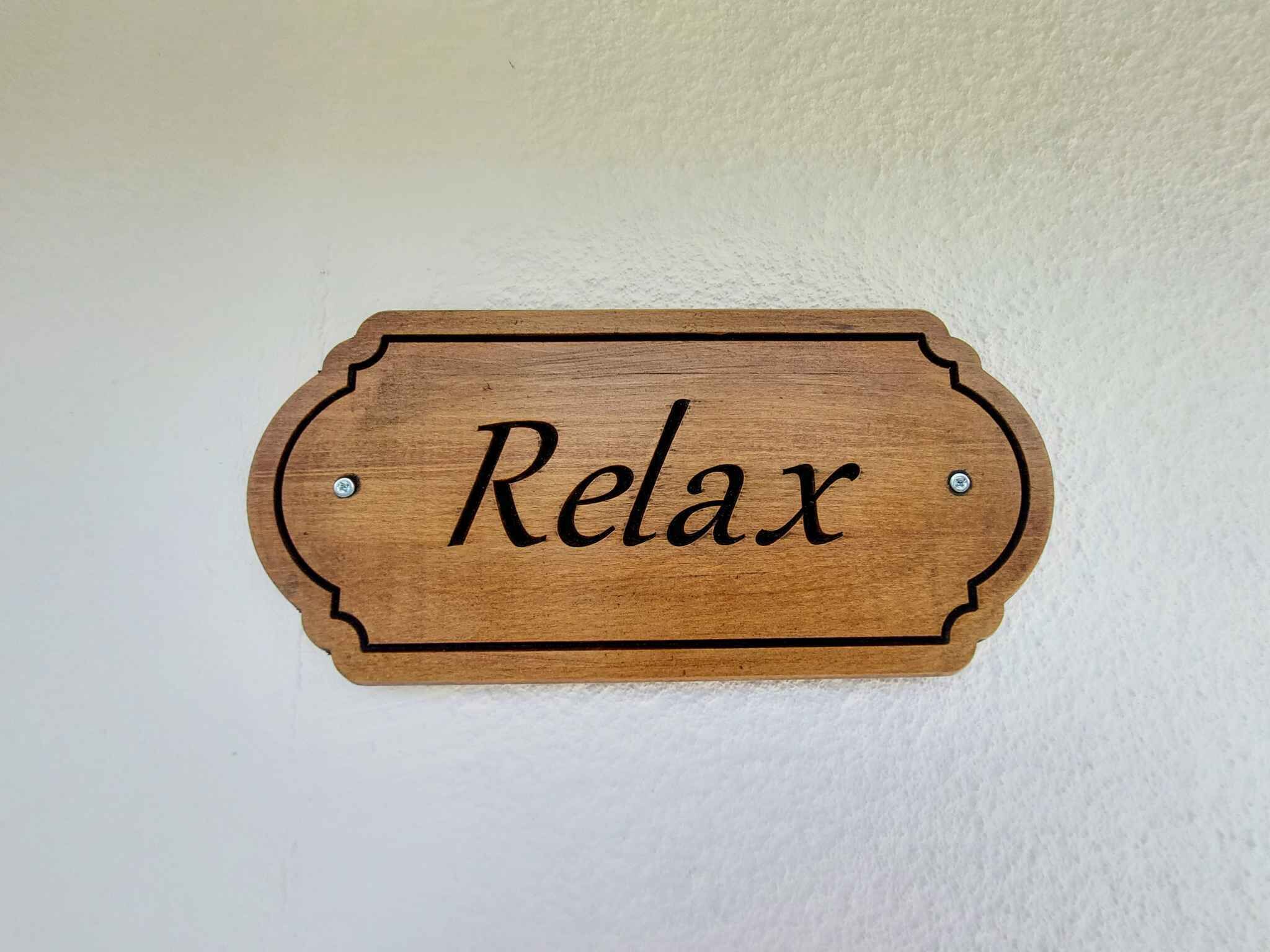 A wooden sign with the word "Relax" on it.