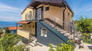 Una casa de dos pisos con un balcón y una escalera que conduce al nivel superior.