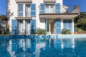Un edificio de dos pisos con una piscina delantera.