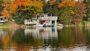 A lakeside cabin with a dock and a covered deck area.