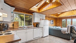 A kitchen with white cabinets, a stove, and a sink.