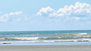 Una spiaggia con onde e cielo sereno.
