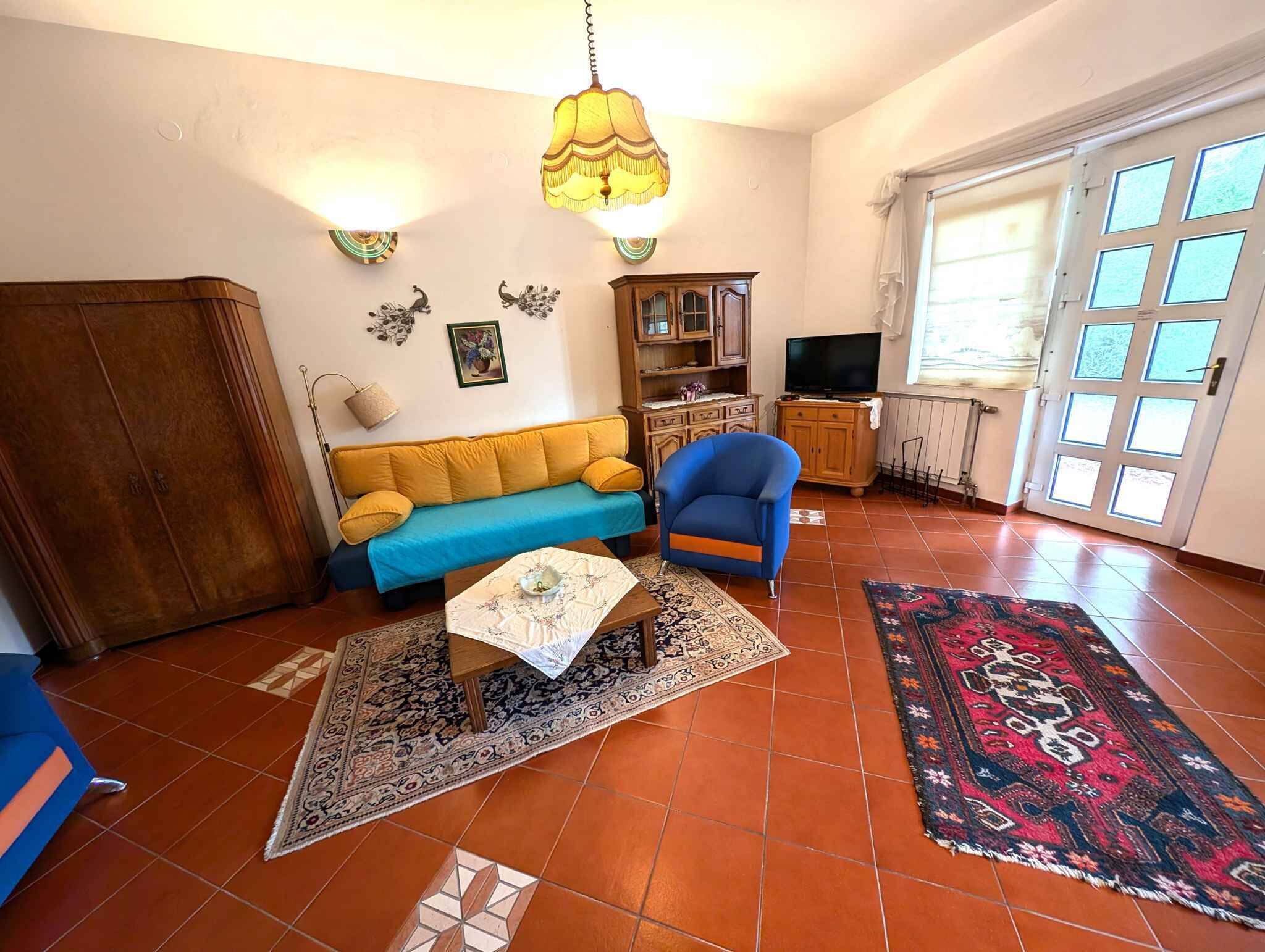 A living room with a sofa, armchair, and a television.