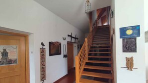 A hallway with a wooden staircase, a wooden door, and a wall with a framed certificate. - Holiday apartment with terrace and garden (Kehidakustány)
