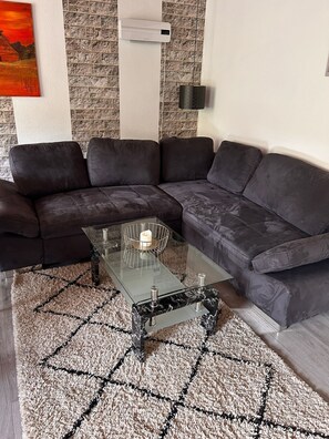 A modern living room with a sectional sofa, a glass coffee table, and a patterned rug. - Beautiful large vacation home in Nehren on the Moselle (Nehren)