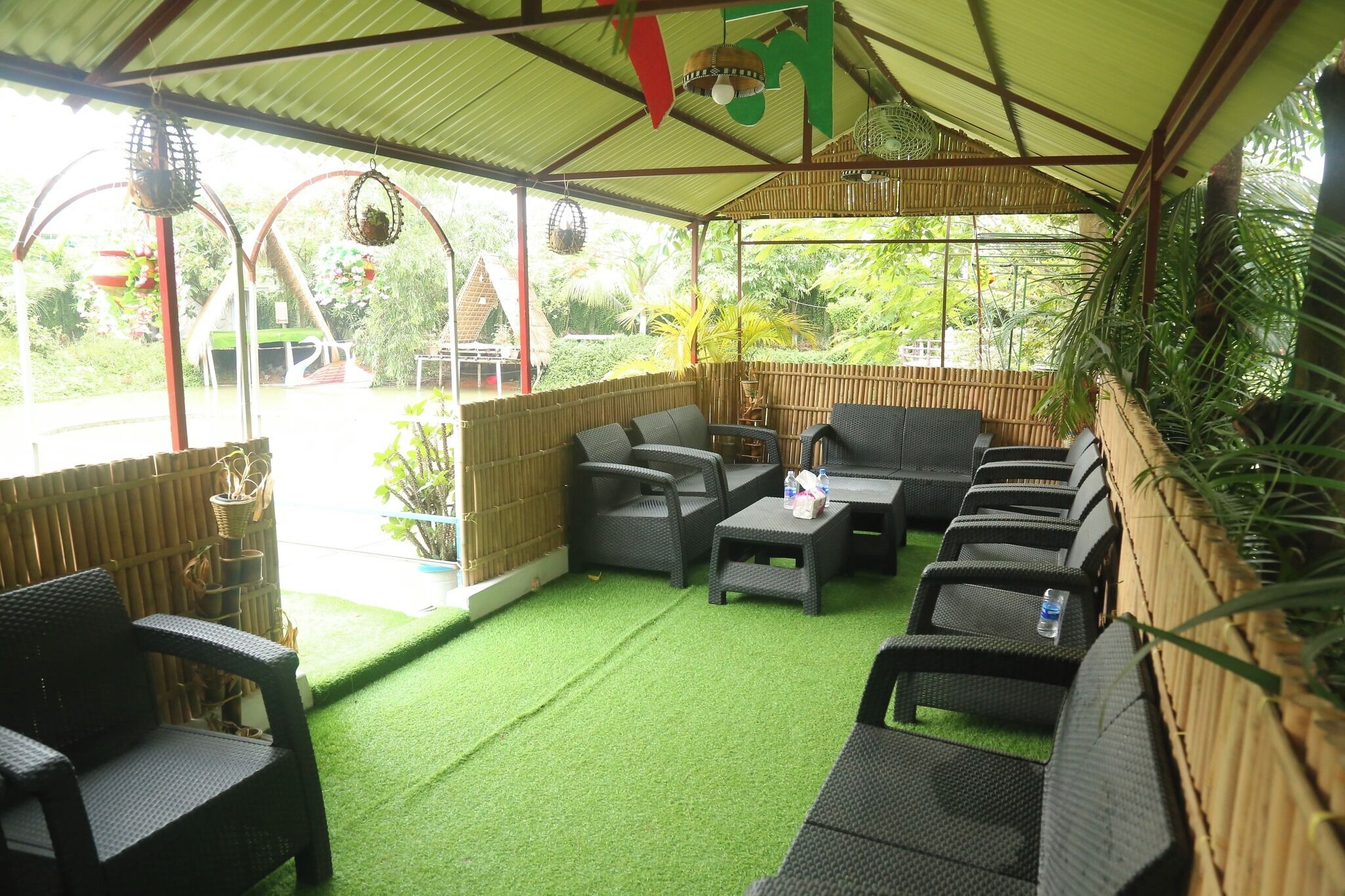 An outdoor seating area with wicker furniture and a green artificial turf floor.