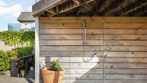 A wooden exterior wall with a built-in shower.