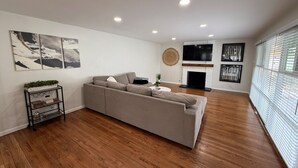 Un salón con sofá, chimenea y televisor montado en la pared.