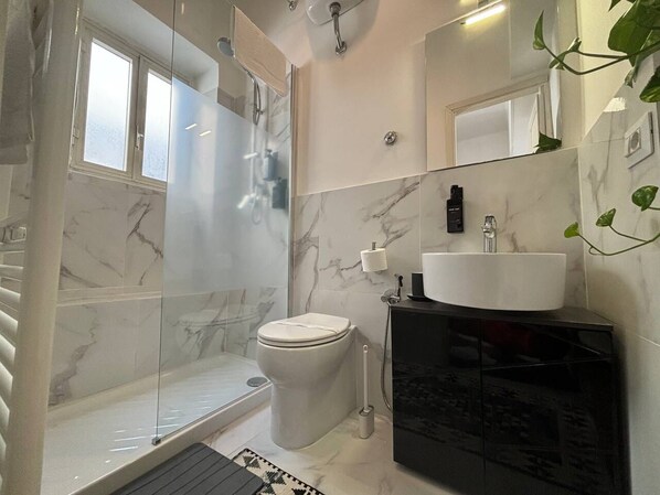 A modern bathroom with a glass-enclosed shower, a white toilet, and a black vanity with a white sink. - Sweet Home Vicolo 2minutes walking from Piazza Navona and 5-7 from Vatican
(Roma)