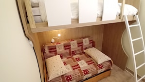 Ein Stockbett mit unterem Bett und einer Leiter.