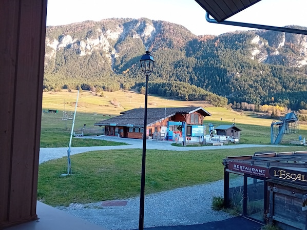 Vista de la montaña con un edificio de madera, un letrero que dice 'Giraffe' y un restaurante llamado 'L'Escal'.