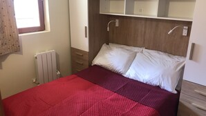 A bedroom with a bed, a radiator, a window with curtains, and a wardrobe. - Terrasses D 305 - PARC NAT. VANOISE appart. 6 pers (Val Cenis)