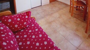 Eine kleine Küche mit Mikrowelle, Spüle und Holzschränken. Es gibt einen Essbereich mit Tisch und Stühlen.