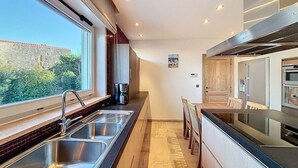 Una cucina moderna con una grande finestra, lavello in acciaio inossidabile e forno a incasso.