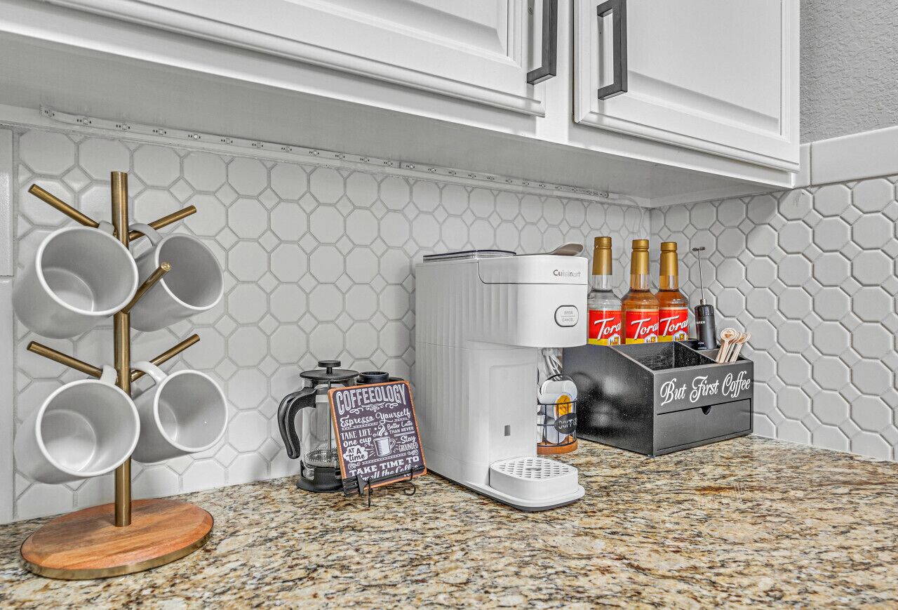 A kitchen with a coffee machine, a coffee station, and a box of Toraja coffee.