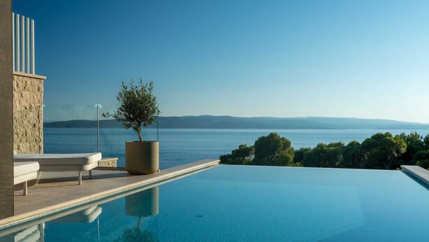 A modern infinity pool with a clear view of the sea and distant mountains. - Luxury Villa Beyond Waves with Pool (Baška Voda)