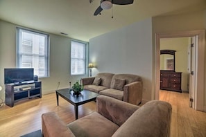 Una sala de estar con sofá, mesa de centro y mueble para televisión.