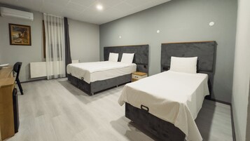 Habitación de hotel con dos camas, un escritorio y una silla.