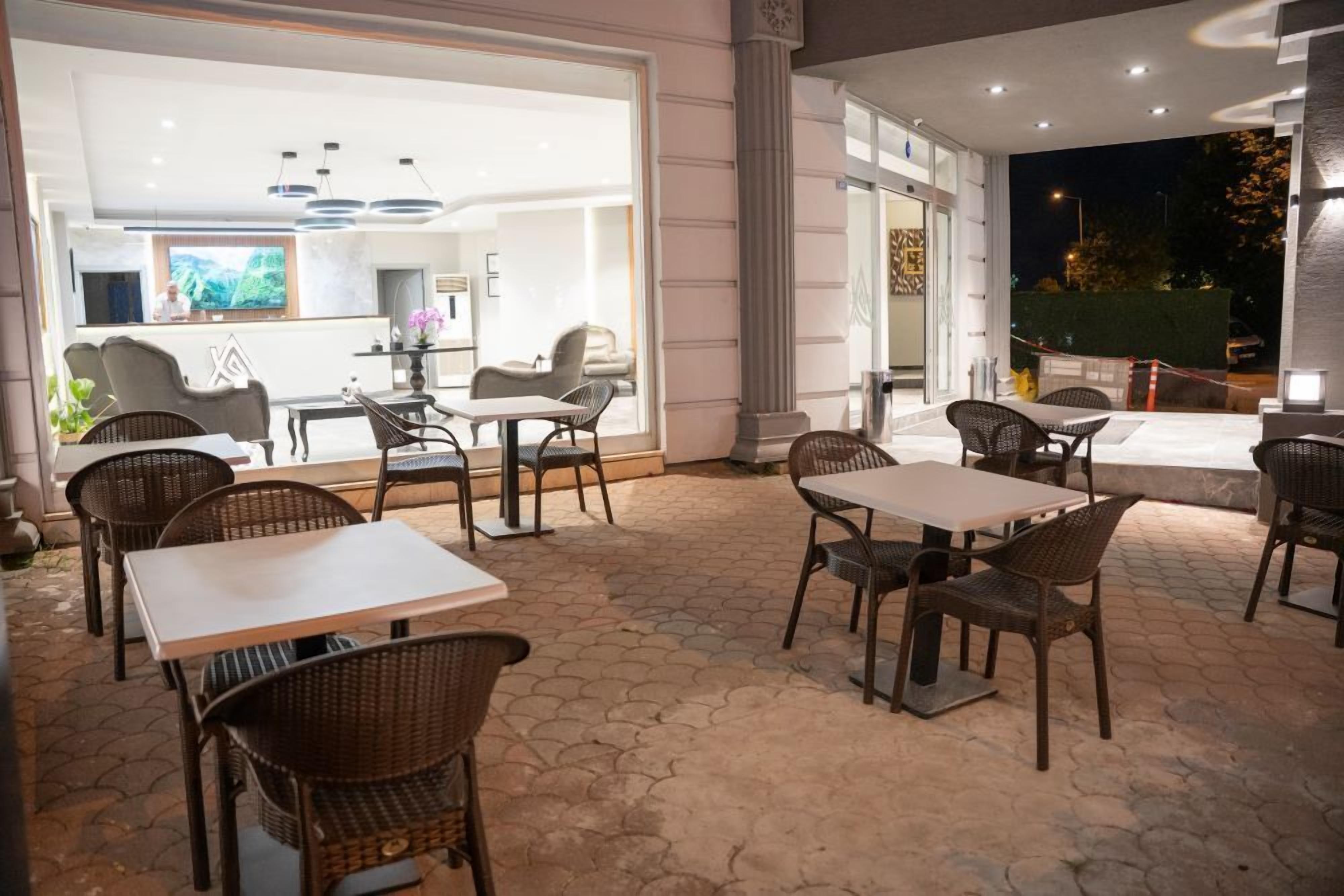 An outdoor patio area with wicker furniture and a large TV screen in the background.