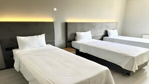 A hotel room with three single beds, a wooden nightstand, and a modern headboard. - Altınova Hotel Sakarya  (Serdivan)