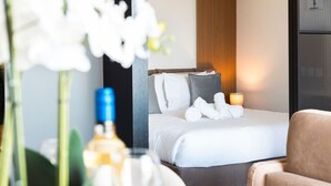 Une chambre d’hôtel avec un lit, des oreillers, une table de chevet, une lampe et une chaise.