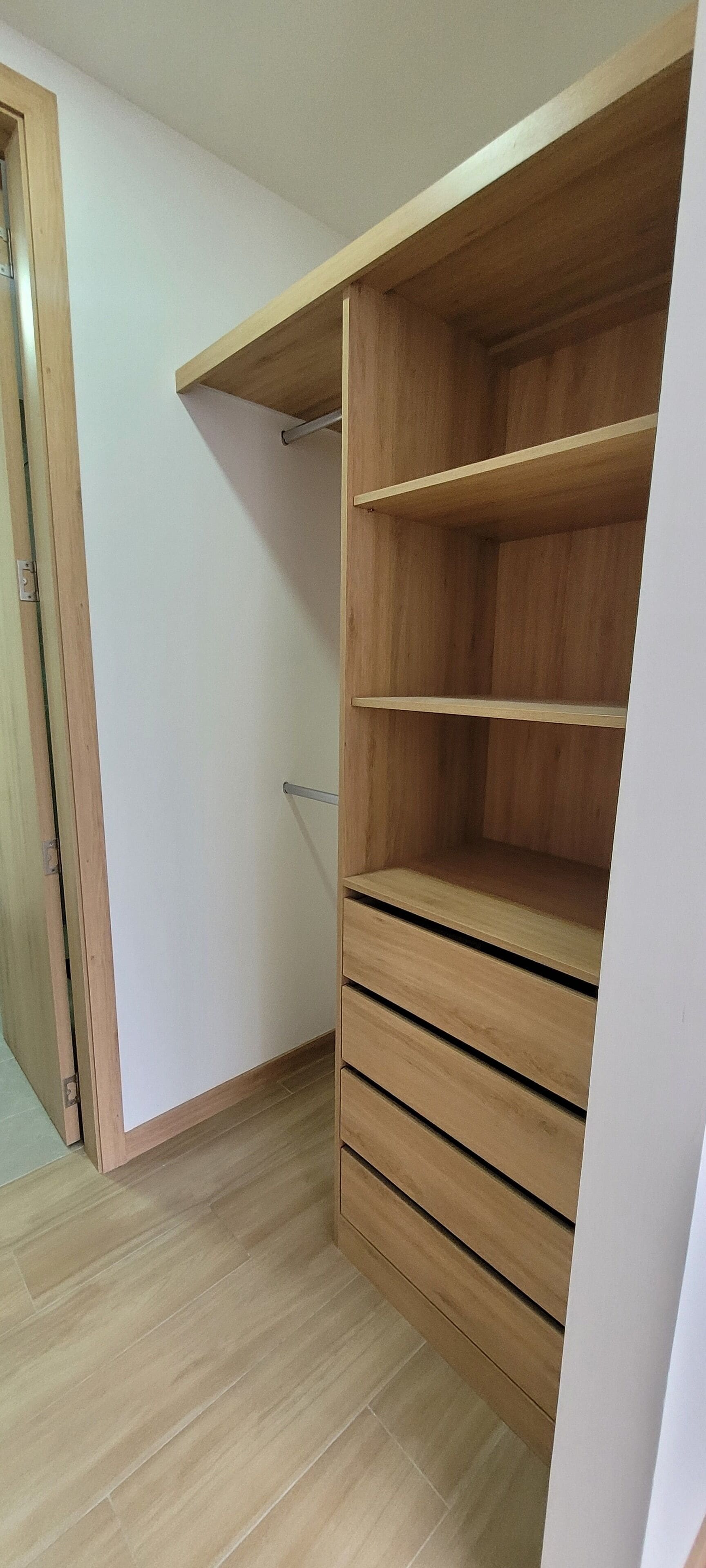 Un vestidor con estantes y cajones de madera.