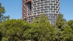 A modern, cylindrical high-rise building with a unique architectural design, featuring multiple balconies and large windows. - Epiq Residences (Quito)