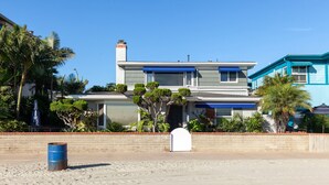 A modern two-story house with a flat roof, a chimney, and a front garage door.