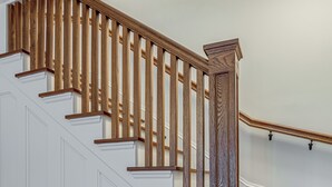 A wooden staircase with white walls and a white door.
