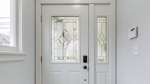 A white door with a glass panel and a keypad lock.