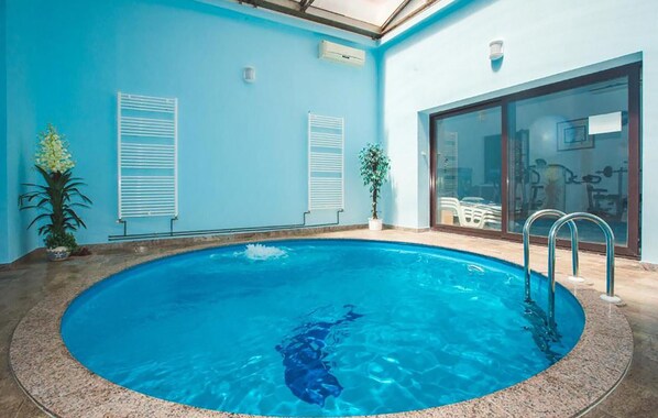 Relax by the oval-shaped pool surrounded by lush greenery and natural light.